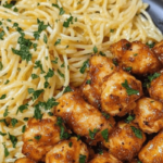 Garlic butter chicken bites served alongside lemon Parmesan spaghetti, creating a zesty and creamy meal.