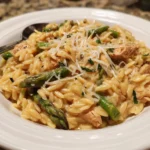 High protein chicken orzo dish with vegetables and herbs served in a bowl