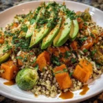 A vibrant Sweet Potato Brussels Sprouts Quinoa Bowl topped with fresh herbs