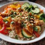 Colorful Thai Peanut Chicken Buddha Bowl with fresh vegetables and peanut sauce