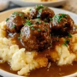 Slow Cooker Salisbury Steak Meatballs served with gravy and vegetables.