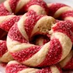 Festively decorated candy cane cookies on a baking tray