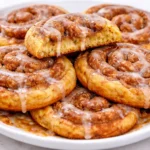 Deliciously baked cinnamon roll cookies topped with icing and cinnamon swirl.