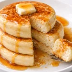 Fluffy cloud-like pancakes stacked on a plate with syrup