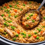Bowl of delicious crockpot chicken fried rice garnished with vegetables.