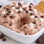 Delicious hot chocolate dip recipe topped with marshmallow fluff in a bowl.