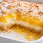 Slice of lemon cream cheese dump cake on a plate with lemon slices