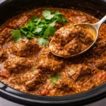 Slow cooker beef coconut curry served in a bowl with herbs