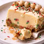 Slice of delicious sugar cookie cheesecake topped with colorful sprinkles