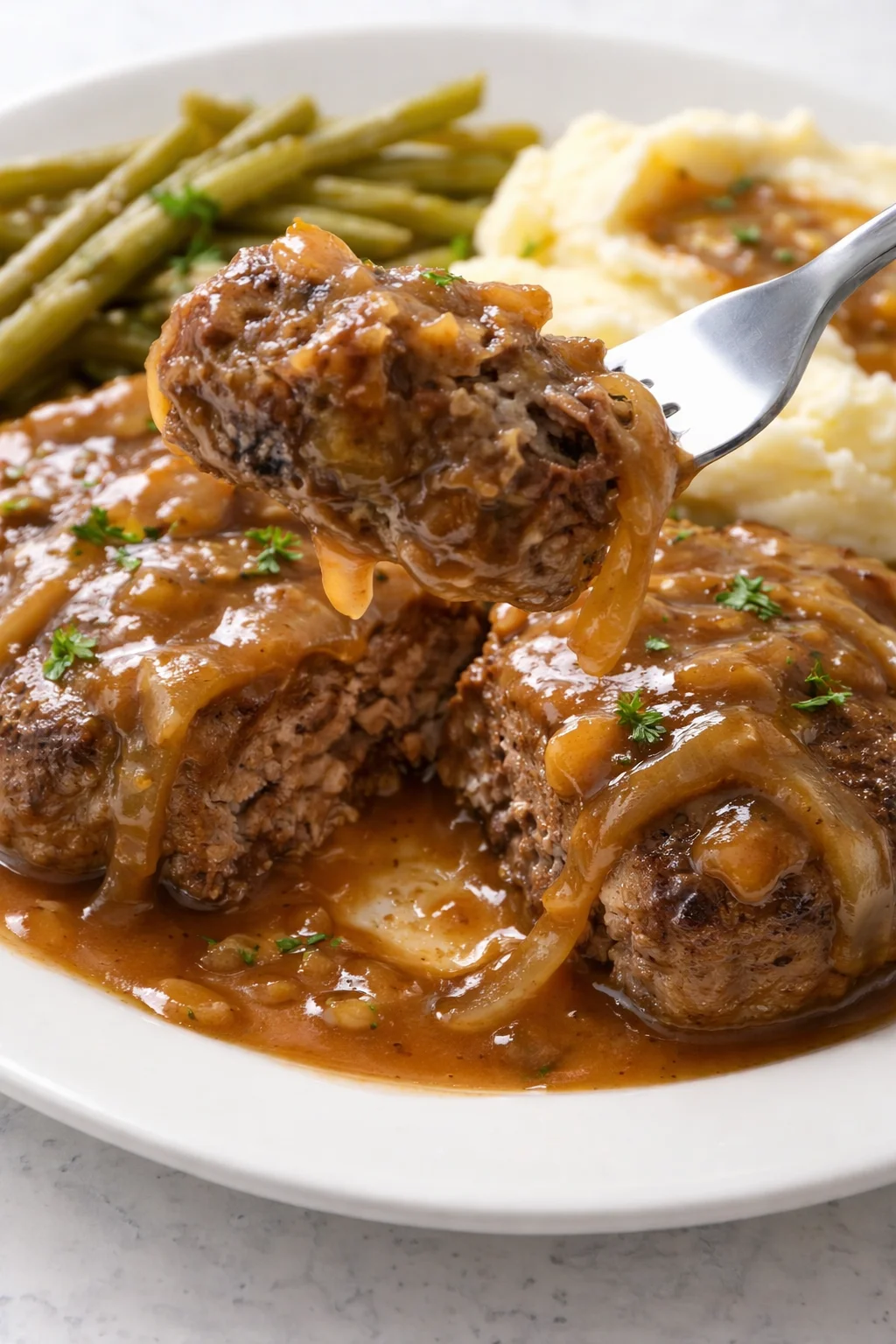 Tender hamburger steaks served with savory onion gravy for a hearty dish.