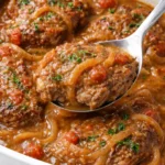 Delicious Swiss steak smothered in savory onion gravy served on a plate.