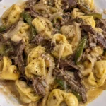 Cheesesteak tortellini in creamy provolone sauce served in a bowl