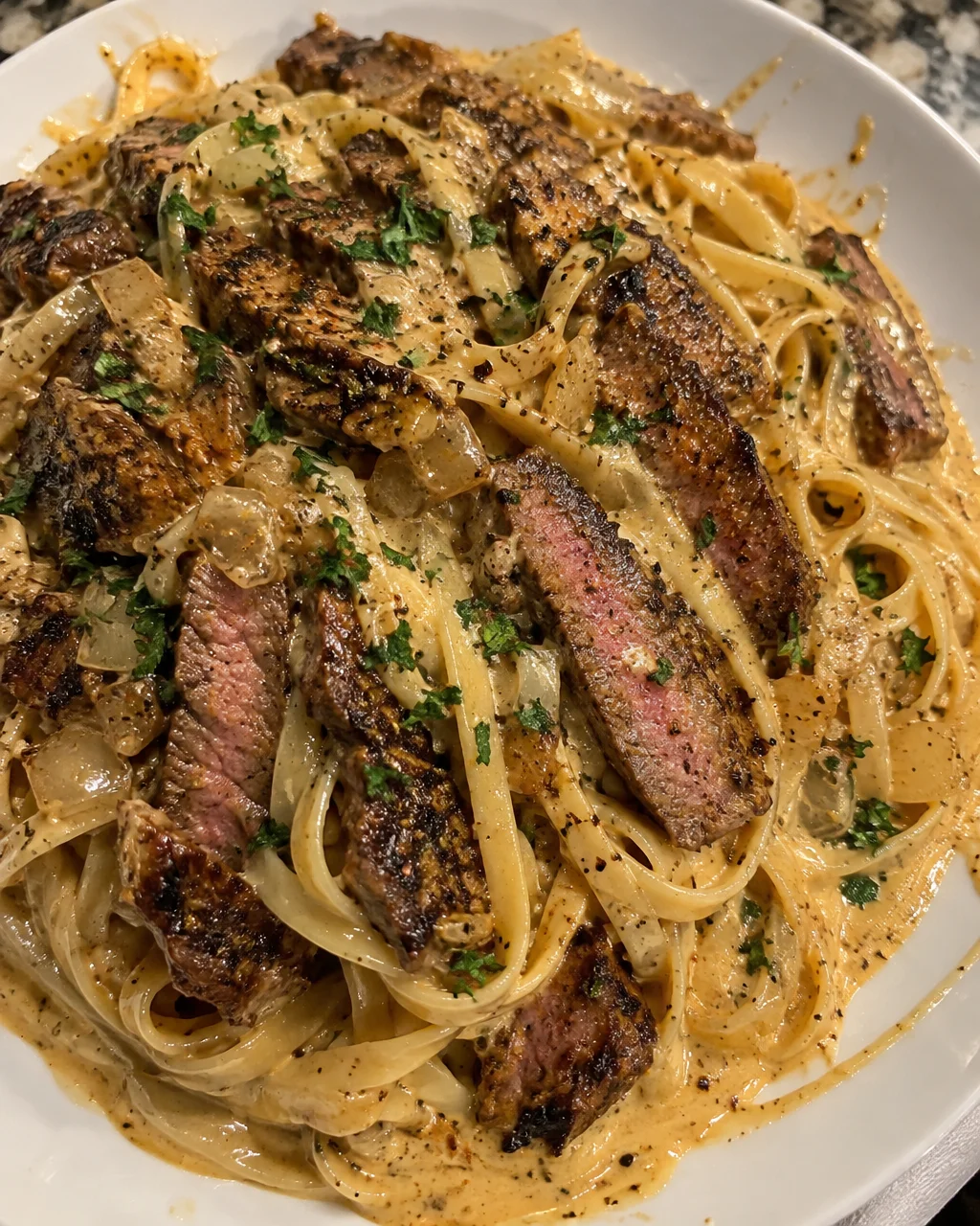 Creamy Cajun Steak Alfredo served on a plate with garnish