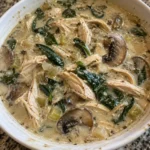 Bowl of creamy rotisserie chicken mushroom soup garnished with herbs