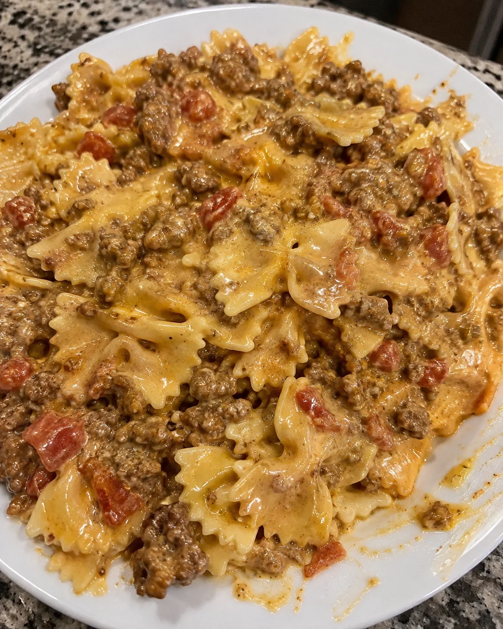 Creamy Velveeta bowtie pasta with beef in a bowl garnished with parsley
