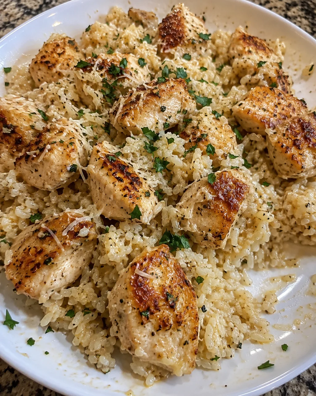 Garlic Parmesan Rice served with crispy chicken bites on a plate